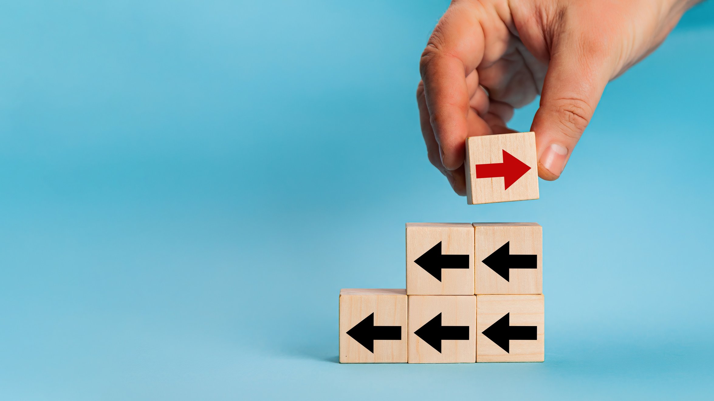 Businessman Hand Picked Wooden Block with Red Arrow Facing the O