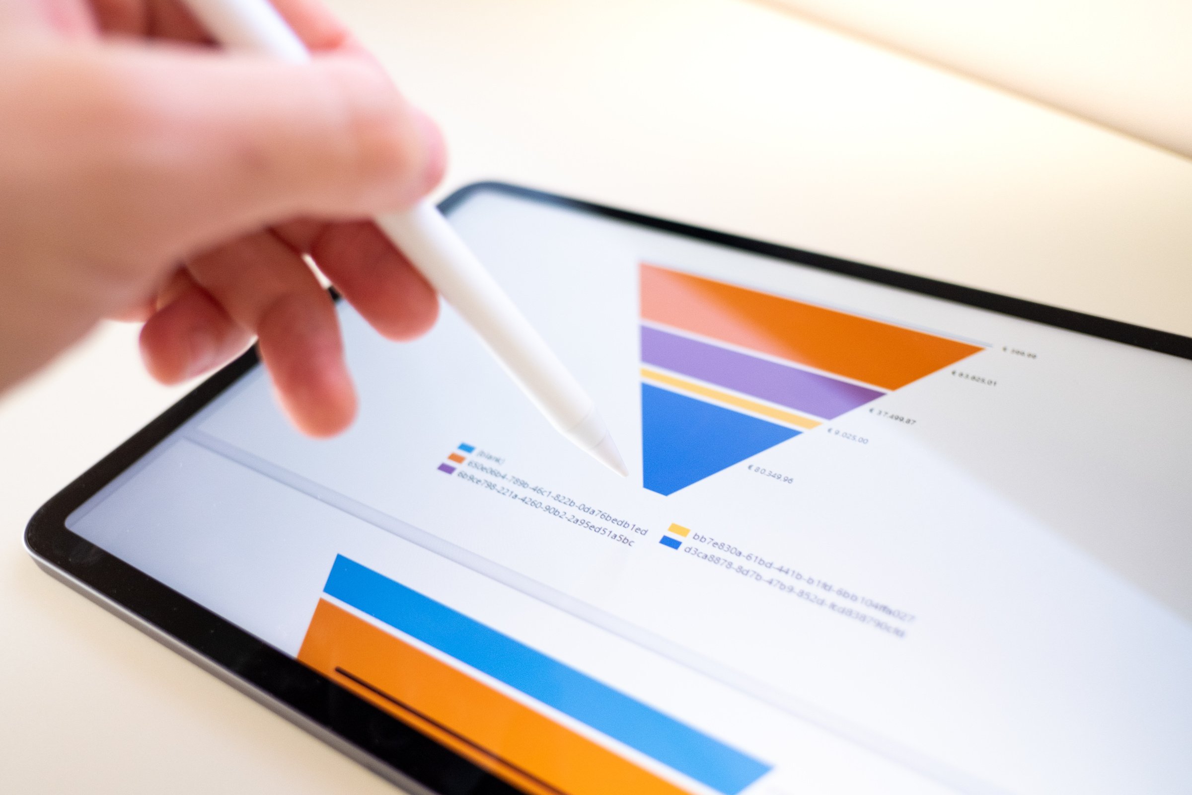 Sales marketing funnel showed on a tablet screen by a young marketer, sales manager pointing data with his pen.